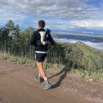 Runner on mountain trail with clouds