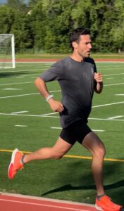 Person running on a track field.