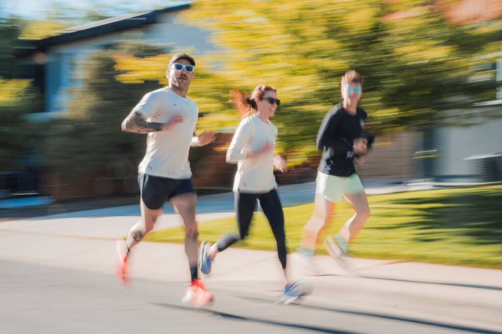 Three people running outdoors together.